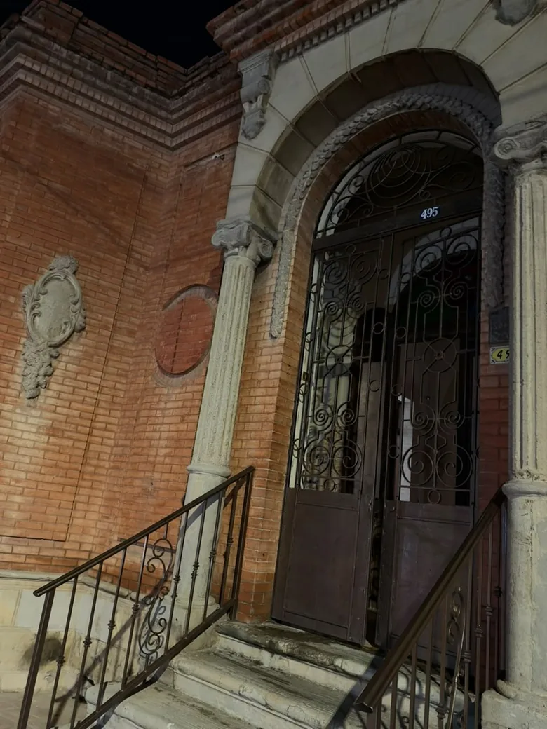 La puerta de acceso, de herrería, entre columnas de cantera, con el número 495.